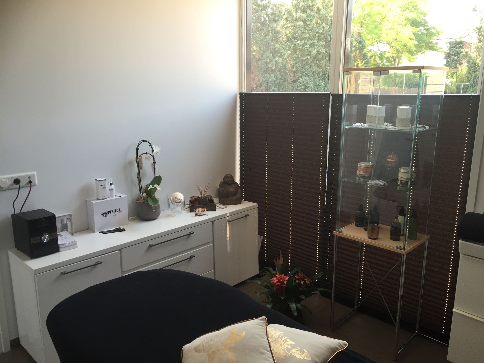 De beautyruimte met behandelstoel, vitrine en kamerscherm