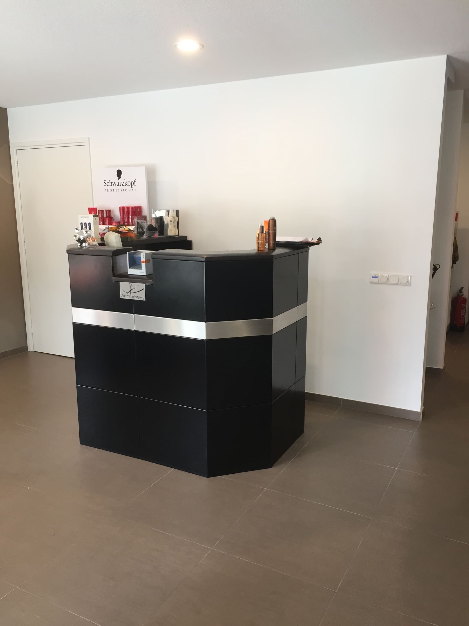 De zwarte balie bij de ingang van de kapsalon